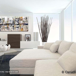 May include: Abstract painting with a white background and colorful geometric shapes. The painting is hanging on a white wall in a modern living room with a white couch and a coffee table.