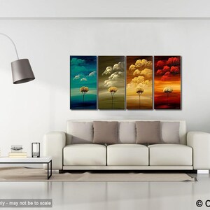 May include: A set of four abstract paintings depicting stylized trees in different colors. The paintings are arranged in a row on a white wall above a white sofa with beige pillows. The paintings are in shades of blue, green, yellow, and red.