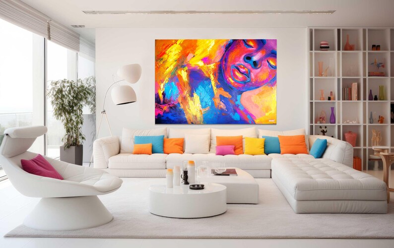 May include: A modern living room with a large abstract painting in vibrant colors of yellow, orange, blue, and pink. A white sectional sofa with colorful throw pillows and a white chair complete the contemporary design.