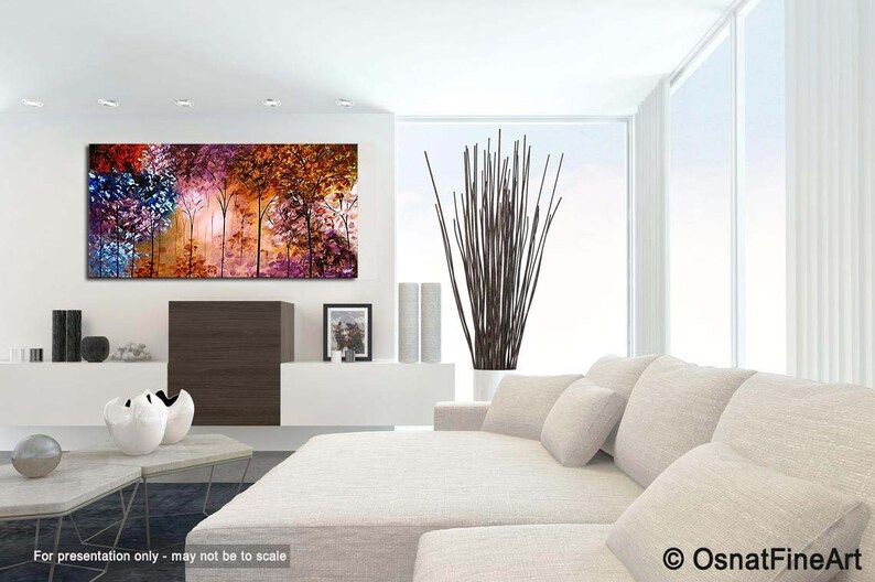May include: Abstract painting of a forest with colorful trees in shades of pink, purple, blue, orange, and brown. The painting is displayed on a white wall in a modern living room setting.