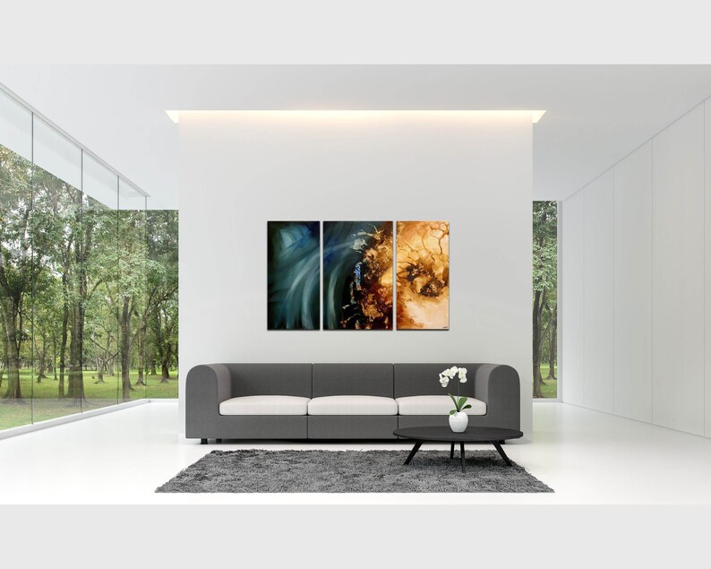 May include: A three-piece abstract art print set featuring a blue and green swirl on the left, a brown and gold swirl in the middle, and a brown and gold swirl on the right. The prints are displayed on a white wall above a gray couch in a modern living room.