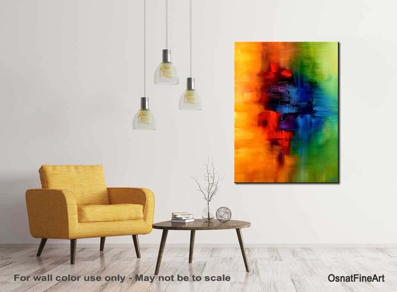 May include: Abstract painting with vibrant colors of yellow, orange, red, blue, green, and purple. The painting is on a canvas and is framed. The painting is hanging on a white wall in a living room setting.