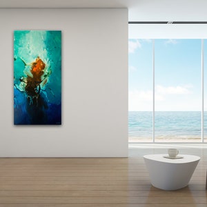 May include: Abstract painting with blue, green, and orange colors. The painting is hanging on a white wall in a modern living room with a view of the ocean.