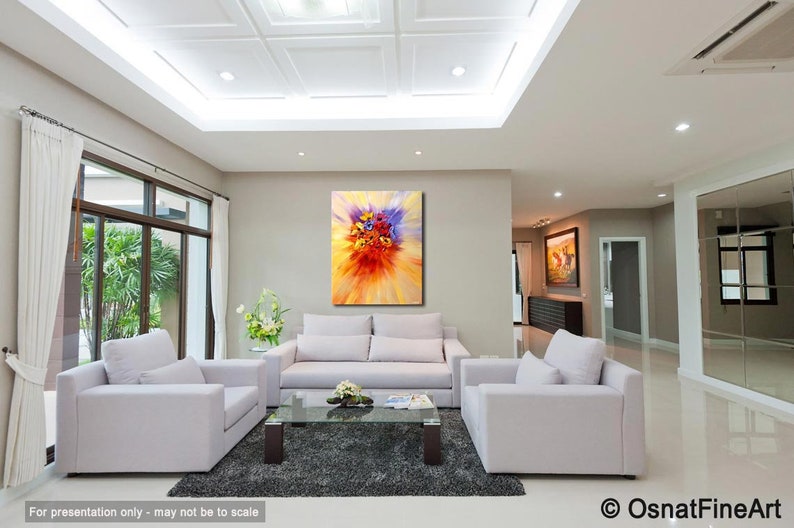May include: A living room interior with white couches and a coffee table. A large abstract painting of a colorful flower bouquet hangs on the wall.
