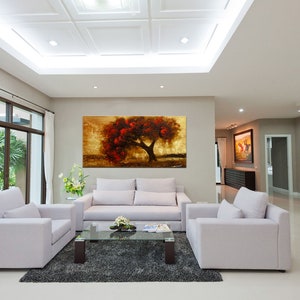 May include: A living room interior with white couches and a coffee table. A large painting of a red tree with a golden background hangs on the wall.