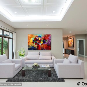 May include: An abstract painting of a bouquet of colorful flowers in a red vase hangs above a white sofa. The artwork features vibrant hues of red, blue, yellow, and purple. The living room has white sofas, a glass coffee table, and a gray rug.