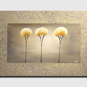 May include: A painting of three stylized trees with yellow foliage against a light gray background. The trees are painted in a minimalist style with simple black trunks and branches. The painting is framed with a textured gold border.