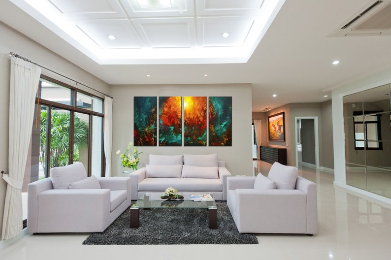 May include: A living room interior with a white sofa and two armchairs, a glass coffee table, and a large abstract painting on the wall. The painting is made up of four panels, each with a different color and design. The room has a modern and minimalist design.
