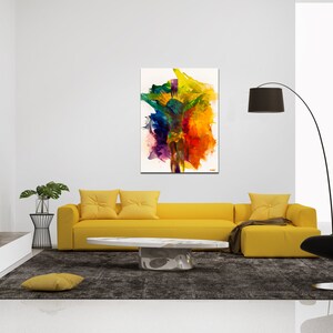 May include: Abstract painting of a colorful figure with a white background. The painting is hanging on a white wall above a yellow sofa with two pillows. There is a black floor lamp and a black chair in the room.