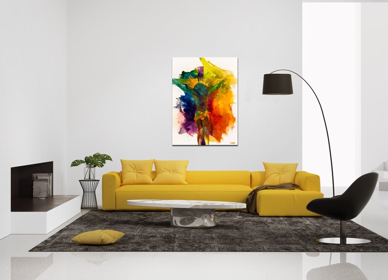 May include: Abstract painting of a colorful figure with a white background. The painting is hanging on a white wall above a yellow sofa with two pillows. There is a black floor lamp and a black chair in the room.