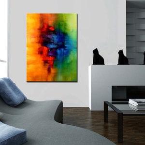 May include: Abstract painting with vibrant colors of yellow, orange, red, blue, and green. The painting is displayed on a white wall in a modern living room setting.