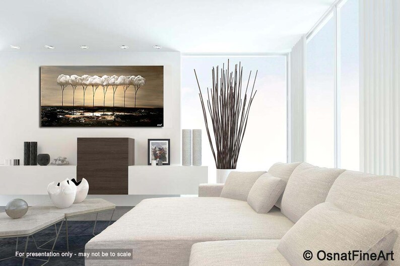 May include: A painting of a row of trees with white clouds as canopies, set against a beige background. The trees are silhouetted against a dark blue sky. The painting is displayed on a white wall in a modern living room setting.