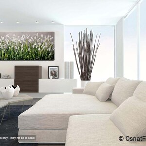 May include: A white couch with white pillows in a modern living room with a large abstract painting of white flowers on a gray background.