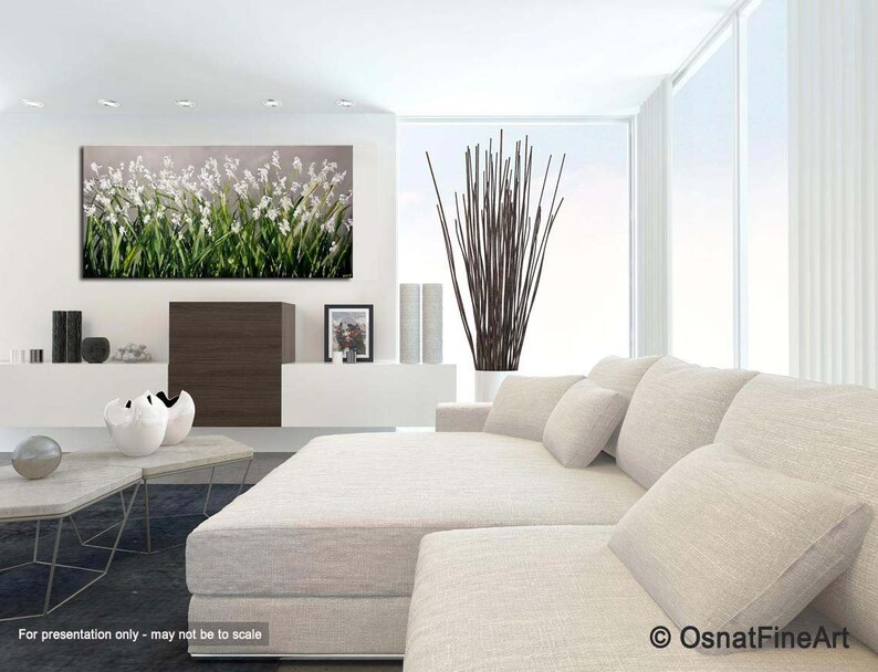 May include: A white couch with white pillows in a modern living room with a large abstract painting of white flowers on a gray background.
