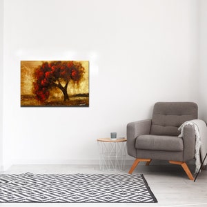 May include: A painting of a tree with red leaves against a gold background. The tree is in the center of the painting and is surrounded by a golden field. The painting is framed and hanging on a white wall.