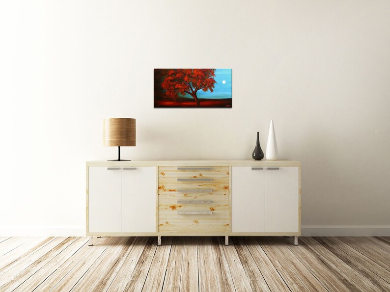 May include: A painting of a red tree with a full moon in the background. The tree is in the foreground and the moon is in the upper right corner of the painting. The sky is a light blue color.