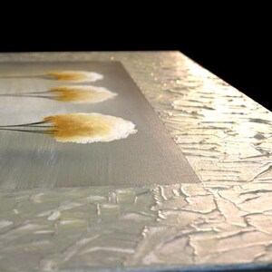 May include: Abstract painting with a textured, white background and four stylized, yellow-brown trees. The trees are painted with a brushstroke effect and have a soft, feathery appearance.