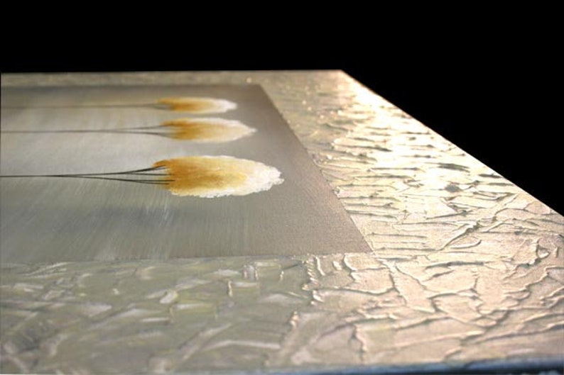 May include: Abstract painting with a textured, white background and four stylized, yellow-brown trees. The trees are painted with a brushstroke effect and have a soft, feathery appearance.