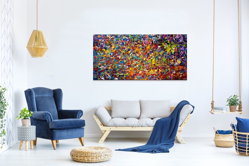 May include: Abstract painting with a colorful, textured, and layered design. The painting features a variety of colors, including red, orange, yellow, green, blue, and purple. The painting is displayed on a white wall in a living room setting.