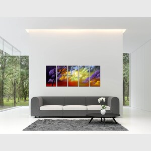 May include: A five-piece abstract art print set featuring a colorful sunset scene with a silhouette of a tree. The print set is displayed on a gray sofa in a modern living room.