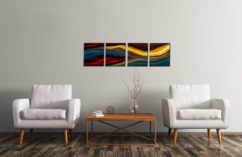 May include: A set of four abstract paintings with a modern design. The paintings are in shades of blue, red, yellow, and brown. The paintings are hung on a white wall above a coffee table and two armchairs.