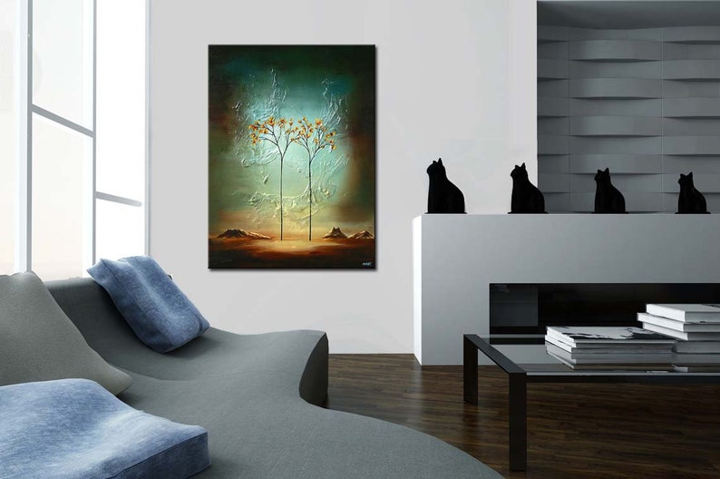 May include: Abstract painting of two trees with orange leaves against a blue and green background. The painting is hanging on a white wall in a modern living room with a gray couch and a black coffee table.