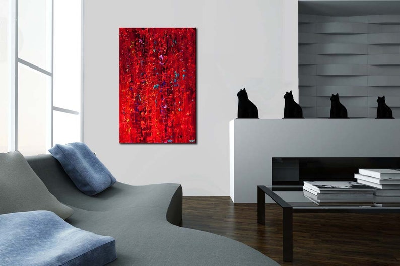 May include: Abstract painting in shades of red, with hints of blue and purple, hanging on a white wall in a modern living room. The painting is above a white fireplace with four black cat figurines on the mantel.