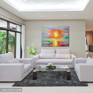 May include: A colorful abstract painting of a sunset over water, hanging on a wall in a living room with white couches and a glass coffee table.
