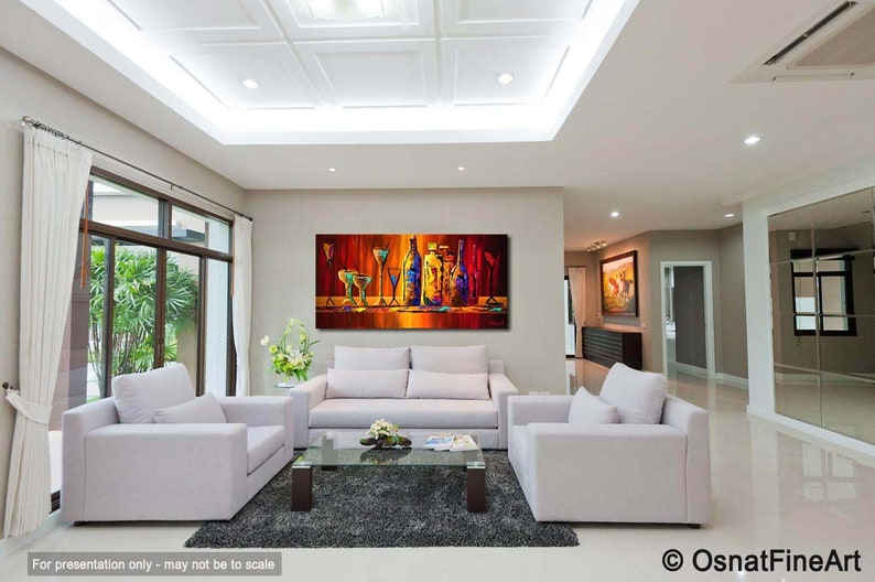 May include: A colorful abstract painting of bottles and glasses on a bar counter. The painting is in a modern living room with white couches and a coffee table.