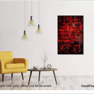 May include: Abstract painting with red, black, and white paint. The painting is hanging on a white wall in a living room setting with a yellow armchair and a coffee table.