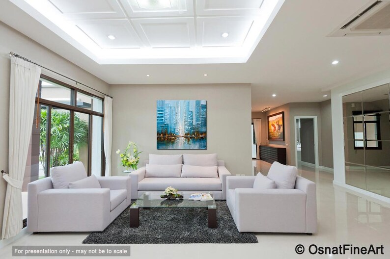 May include: A living room with white couches and a coffee table. A large abstract painting of a city skyline in shades of blue hangs on the wall.