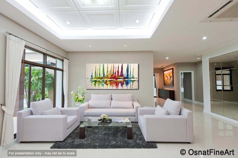 May include: A living room interior with white couches and a coffee table. A large abstract painting of colorful sailboats hangs on the wall. The painting features a reflection of the sailboats in the water.