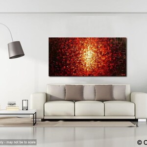 May include: Abstract painting with a bright orange, yellow, and red color scheme. The painting is displayed on a white wall above a white couch with pillows.