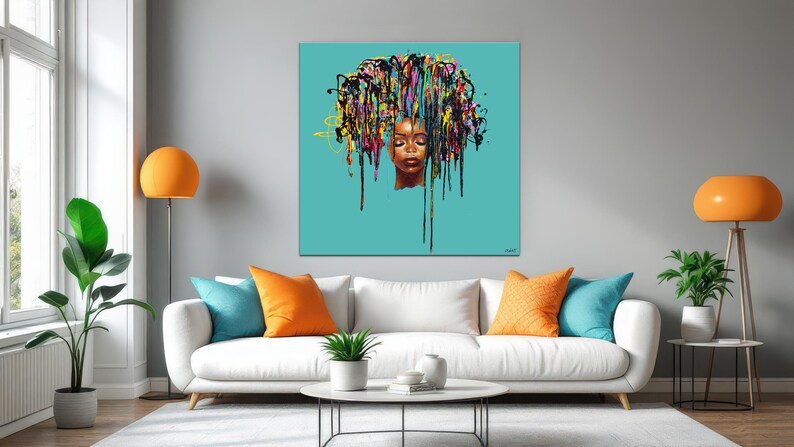 May include: A square canvas art piece featuring a woman's face with closed eyes and a vibrant, colorful hair design. The artwork is set against a teal background, creating a striking contrast. The painting is displayed above a white sofa with colorful pillows.