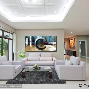 May include: Abstract painting with a large circle in the center, featuring shades of blue, gray, and white. The painting is displayed on a wall in a living room with white couches and a coffee table.