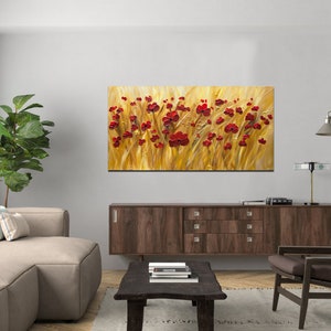 May include: A painting of a field of red poppies against a golden background. The painting is displayed on a wall in a living room setting.
