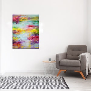 May include: Abstract painting with a colorful, textured style. The painting features a variety of colors, including pink, purple, yellow, green, and blue. The colors are blended together to create a sense of movement and depth. The painting is framed and ready to hang.