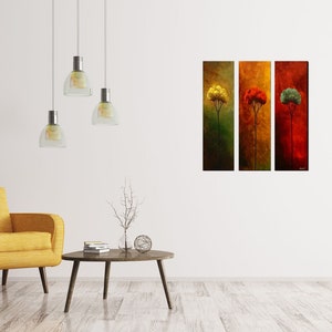 May include: Three vertical canvas prints depicting stylized trees in different colors. The leftmost tree is yellow, the middle tree is red, and the rightmost tree is green. The trees are set against a background of muted brown, orange, and red.