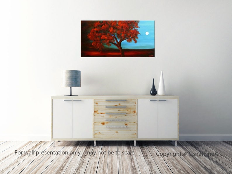 May include: A painting of a red tree with a full moon in the background. The tree is silhouetted against a blue sky. The painting is framed and hanging on a white wall.