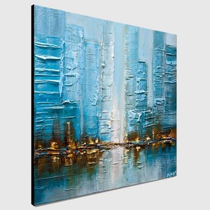 May include: Abstract painting of a city skyline in shades of blue, white, and gold. The painting has a textured surface and depicts a reflection of the city in the water.