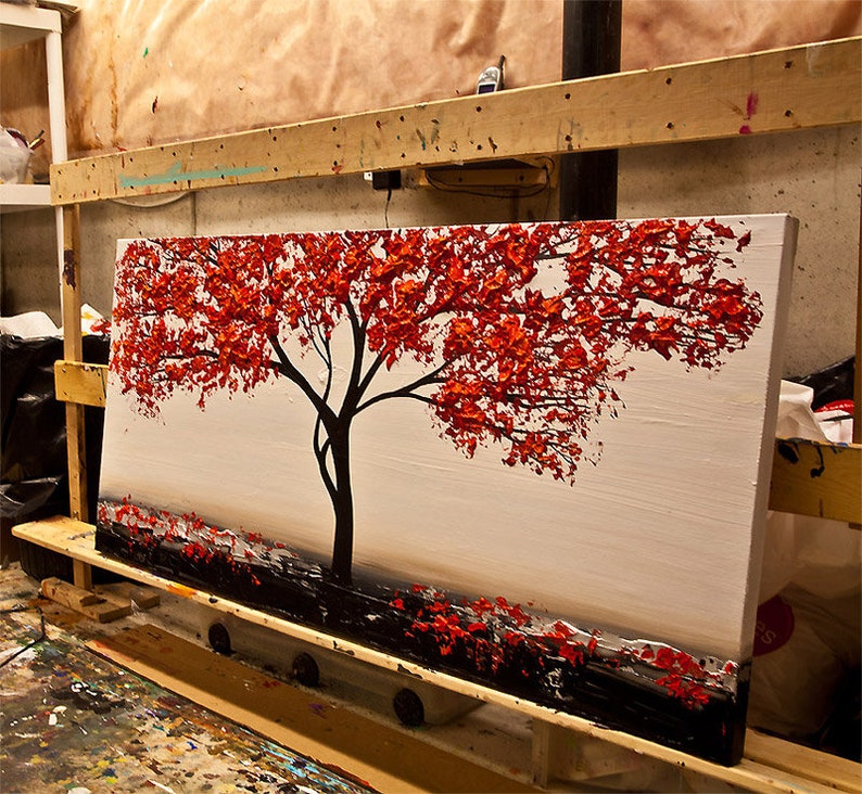 May include: A painting of a red tree with a white background. The tree is painted in a textured style, with thick brushstrokes. The painting is on a canvas and is framed.