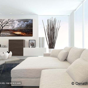 May include: Abstract painting of a tree with white clouds and a brown landscape. The painting is hanging on a white wall in a modern living room with a white couch and a coffee table.