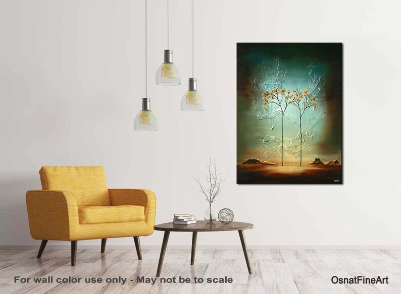 May include: Abstract painting of two trees with yellow leaves against a blue-green background. The trees are silhouetted against a light blue sky. The painting is framed and hanging on a white wall.