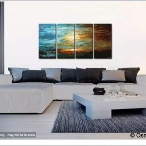 May include: A four-piece abstract painting set depicting a sunset with blue, orange, and brown hues. The painting is displayed on a white wall above a white sectional sofa with gray pillows. A white coffee table with a gray rug sits in front of the sofa.