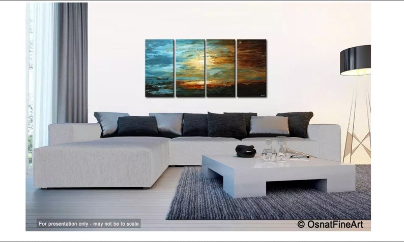 May include: A four-piece abstract painting set depicting a sunset with blue, orange, and brown hues. The painting is displayed on a white wall above a white sectional sofa with gray pillows. A white coffee table with a gray rug sits in front of the sofa.