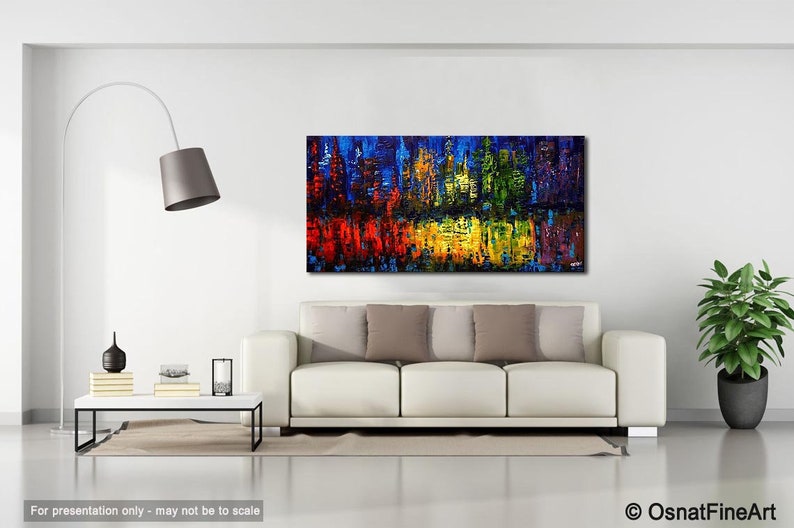 May include: Abstract painting of a city skyline with a reflection in water. The painting is done in a variety of colors, including blue, green, yellow, red, and purple. The painting is displayed on a white wall in a living room setting.