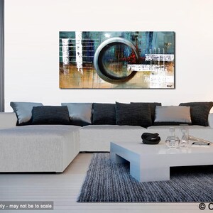 May include: Abstract painting with a large, circular, gray shape in the center. The painting is on a white wall in a living room setting with a gray sectional sofa and a white coffee table.