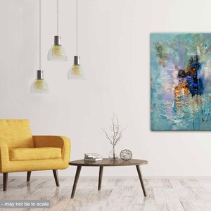 May include: Abstract painting with blue, white, and gold hues. The painting is textured and has a modern style. It is hanging on a white wall in a living room setting.