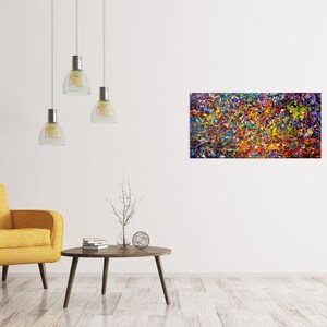 May include: Abstract painting with a colorful, textured, and vibrant design. The painting features a mix of colors, including red, orange, yellow, green, blue, purple, and white. The painting is framed and hanging on a white wall.