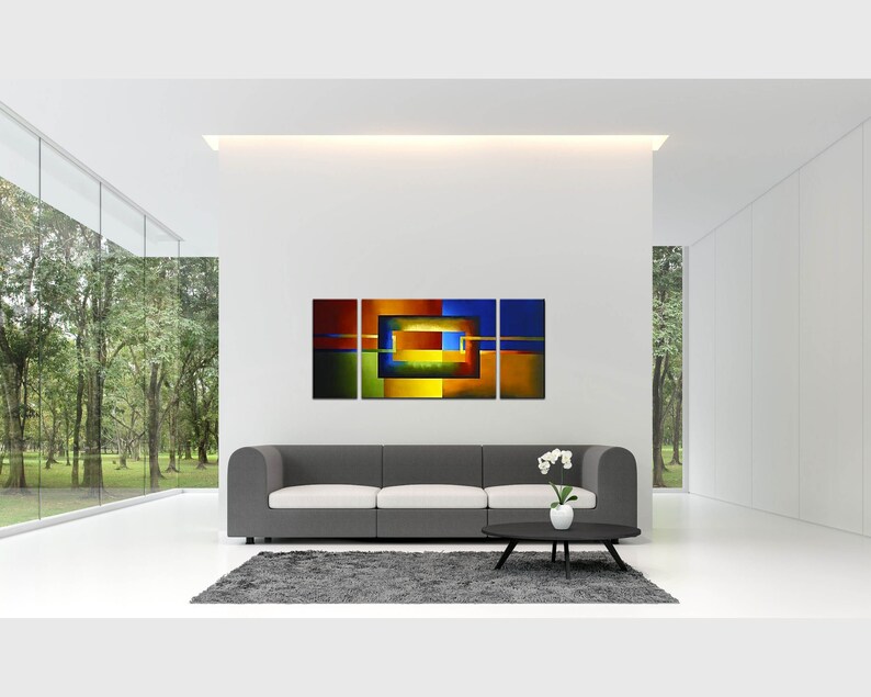 May include: Abstract art print with a geometric design in shades of blue, green, yellow, orange, and red. The print is divided into three panels and features a series of overlapping squares and rectangles.